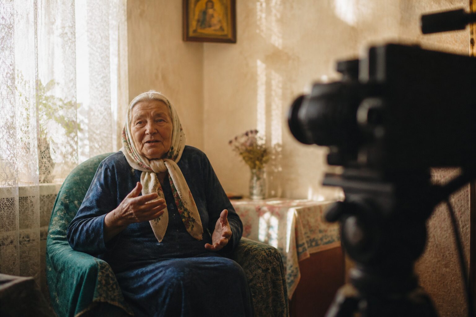 Зйомка інтерв’ю з літньою жінкою у її вітальні біля вікна